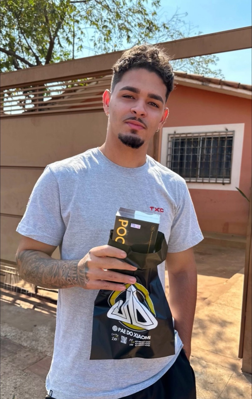 Cliente segurando um smartphone POCO com a sacola do Pai do Xiaomi