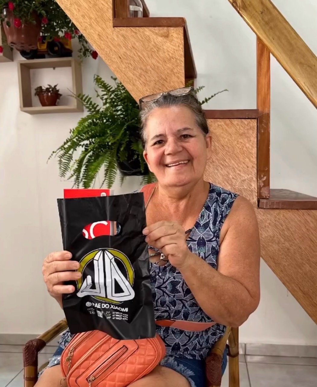 Cliente sorrindo com a sacola do Pai do Xiaomi