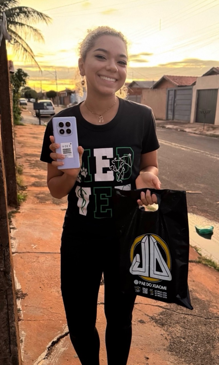 Cliente sorrindo e mostrando seu novo smartphone Xiaomi